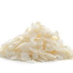 A small heap of dessicated coconut flakes isolated on a white background.